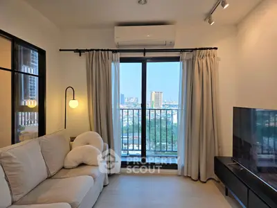 Modern living room with city view, cozy sofa, and large window balcony access.