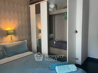 Cozy bedroom with modern wardrobe and soft lighting, perfect for relaxation.