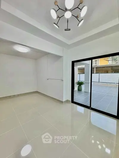 Modern interior with sleek lighting and large sliding doors opening to a spacious patio.