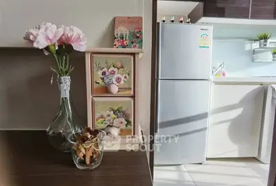 Charming kitchen corner with modern fridge and floral decor, perfect for cozy living.