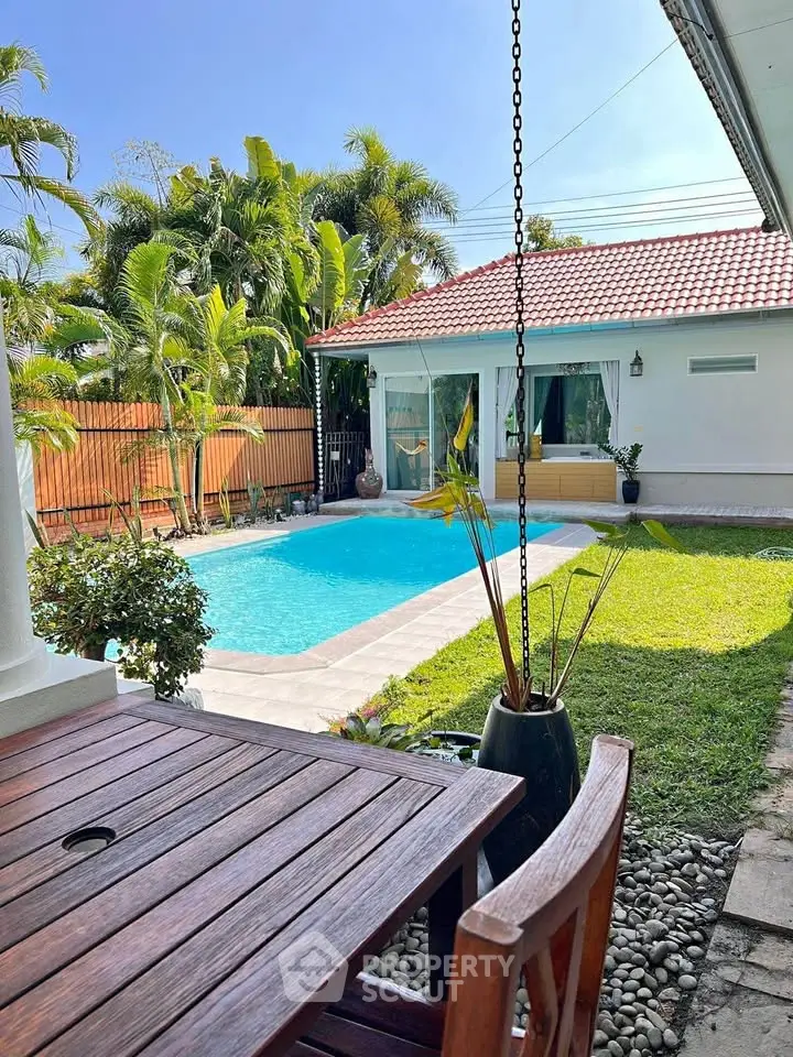 Charming backyard with pool and lush garden in a tropical setting, perfect for relaxation and outdoor dining.