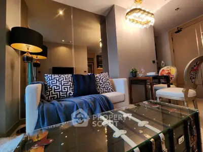 Stylish living room with modern decor, glass coffee table, and elegant lighting.