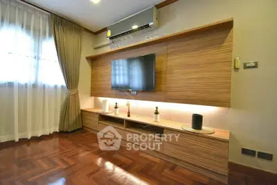 Modern living room with stylish wooden TV unit and parquet flooring