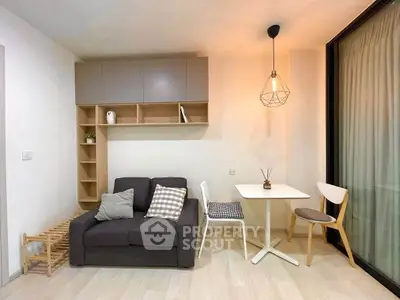 Modern living room with cozy sofa, stylish lighting, and dining area in a compact apartment.