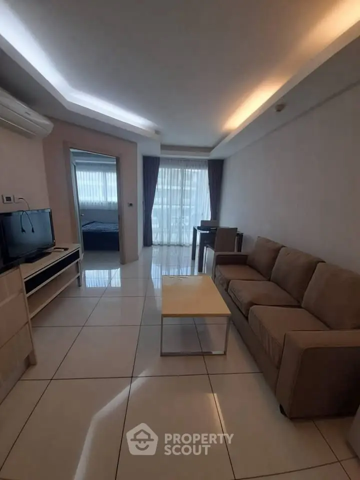 Modern living room with sleek furniture and large windows offering natural light.