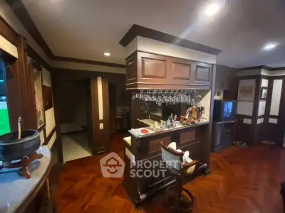 Elegant home bar with wooden cabinetry and parquet flooring
