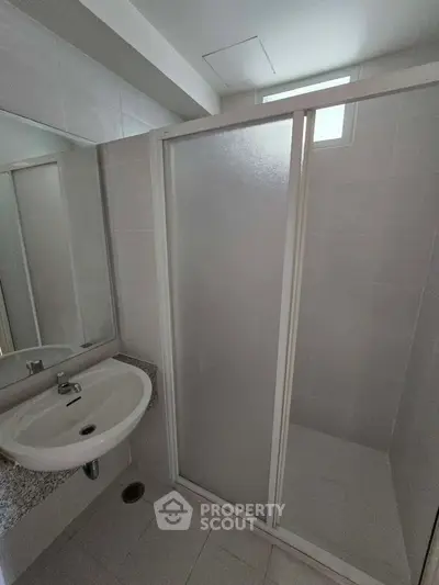 Modern bathroom with sleek shower enclosure and elegant sink design.