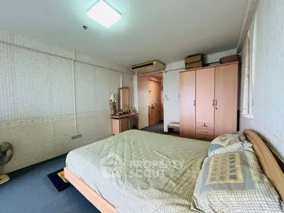 Cozy bedroom with wooden furniture and soft lighting in a modern apartment.