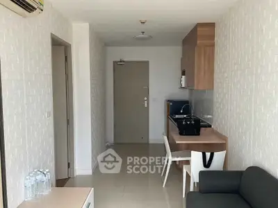 Modern compact apartment interior with kitchen and living area, featuring sleek design and efficient use of space.