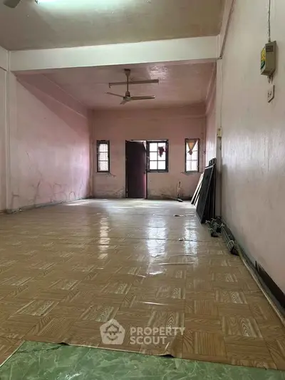 Spacious empty room with tiled flooring and ceiling fan, ideal for customization.