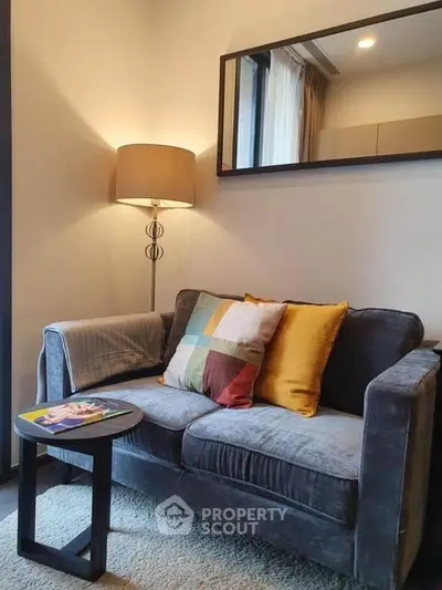 Cozy living room with plush sofa, stylish lamp, and modern decor in a chic apartment.