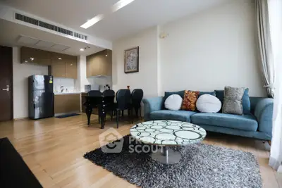 Modern living room with open kitchen, stylish furniture, and cozy decor in a contemporary apartment.