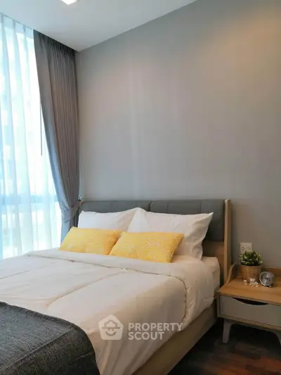 Cozy bedroom with modern decor and natural light, featuring a comfortable bed and stylish furnishings.