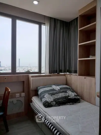 Cozy bedroom with city view, featuring built-in shelves and modern decor.