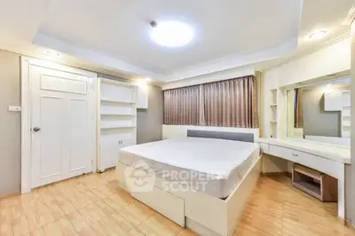 Spacious bedroom with modern design and ample storage in a bright apartment.