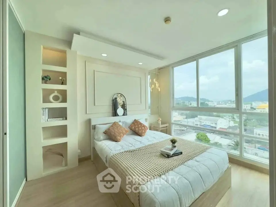 Modern bedroom with large windows offering stunning city views and elegant decor.