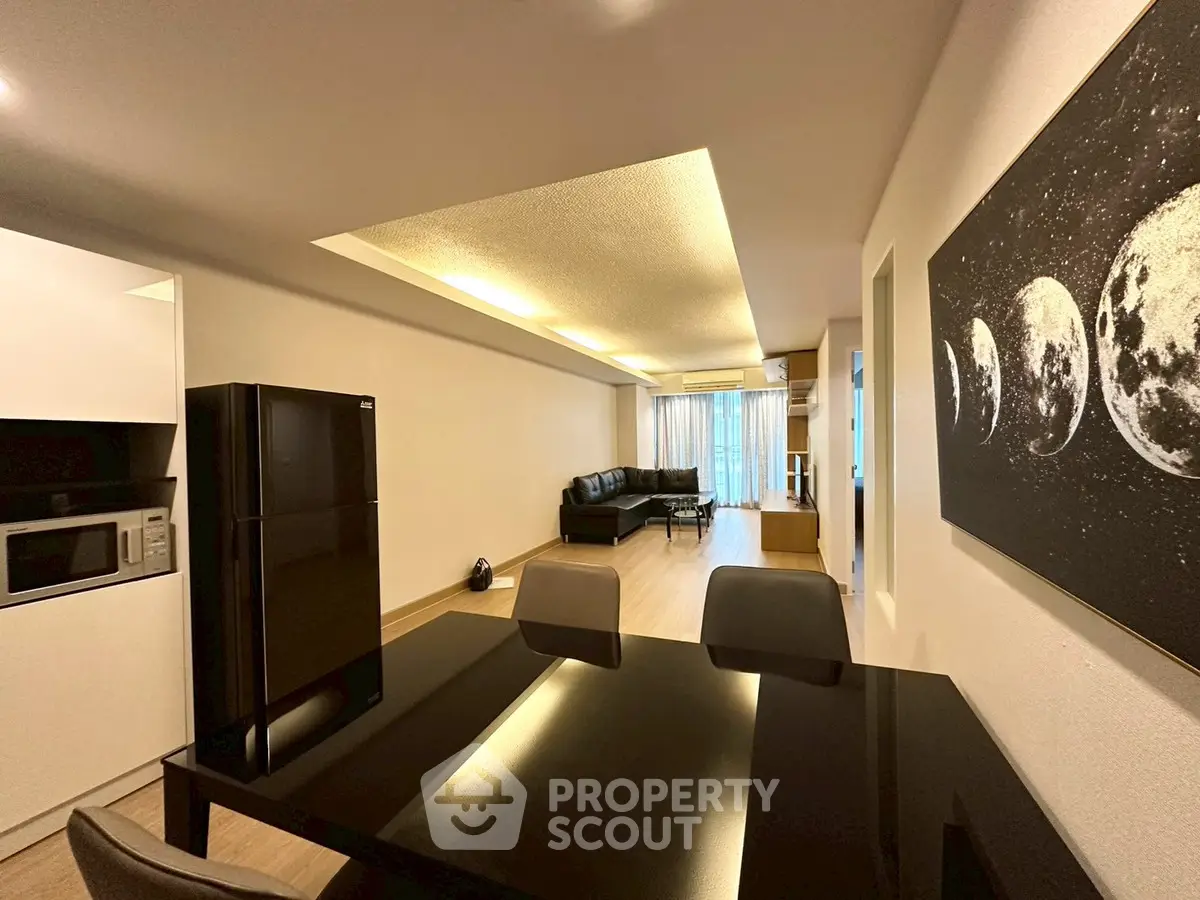 Modern living room with sleek black furniture and stylish lighting, perfect for contemporary living.