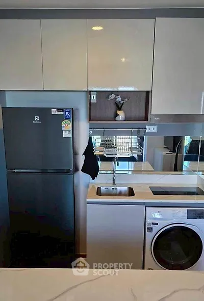 Modern kitchen with sleek appliances and stylish cabinetry in a contemporary apartment.