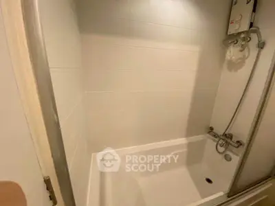 Modern bathroom with sleek bathtub and shower in a minimalist design.