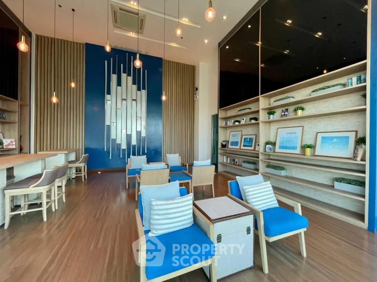 Modern living room with stylish decor and blue accents, featuring a cozy seating area and elegant lighting.