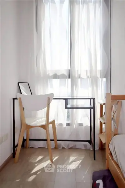Bright study nook with modern desk and chair by a sunlit window, perfect for productivity.