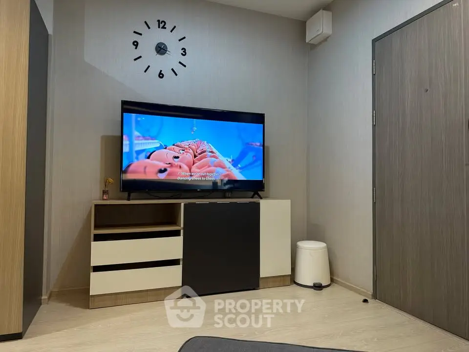 Modern living room with stylish TV setup and wall clock, perfect for cozy evenings.