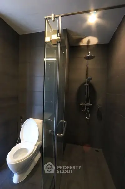 Modern bathroom with sleek shower and toilet in contemporary design.