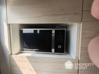 Modern kitchen with built-in microwave in sleek wooden cabinetry