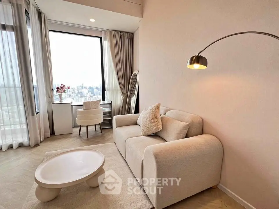 Modern living room with cozy sofa, large window view, and elegant decor in a high-rise apartment.