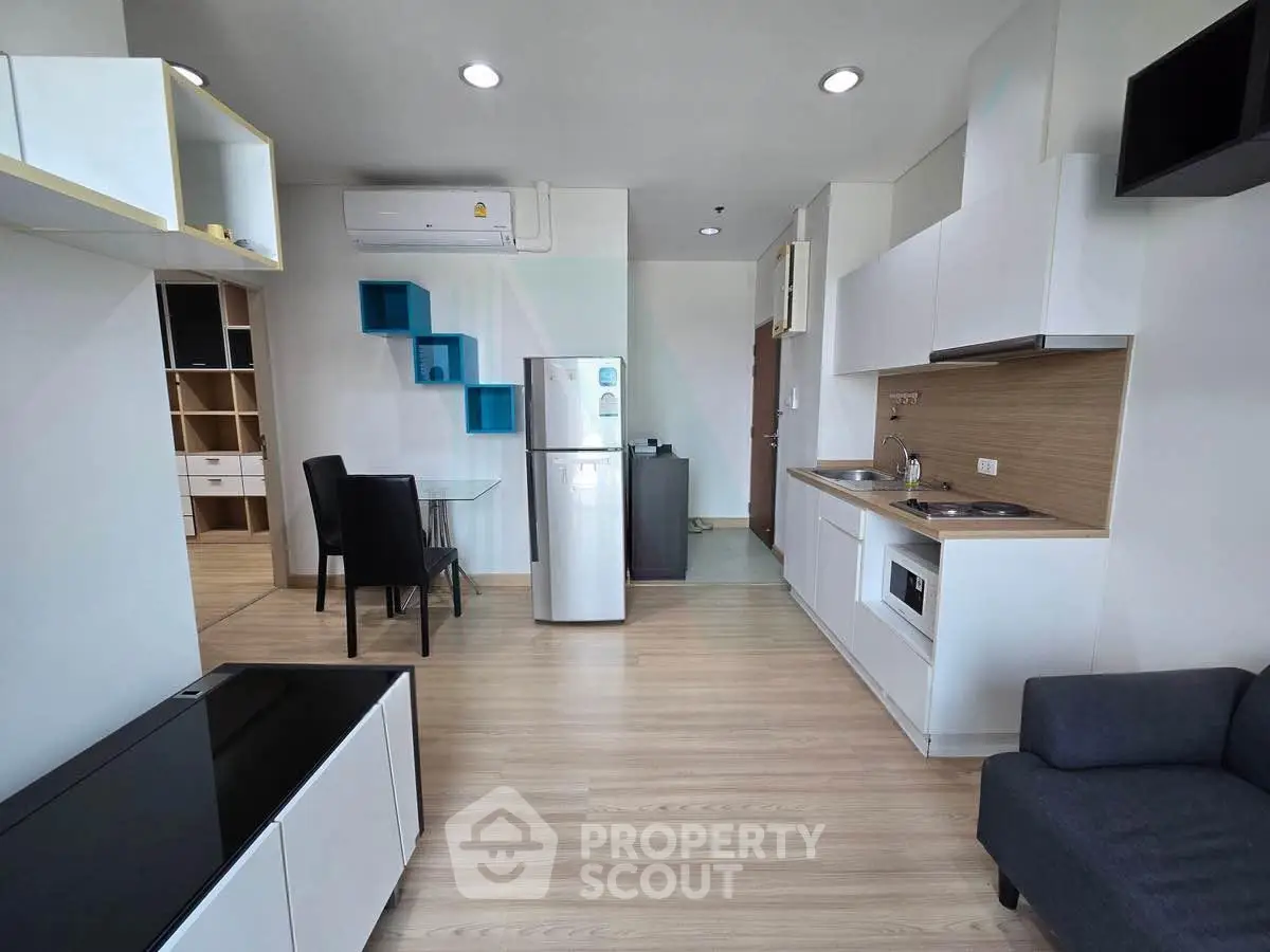 Modern open-layout kitchen and living area with sleek design and ample natural light.