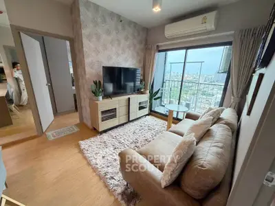 Stylish living room with cozy sofa, TV, and balcony view in modern apartment.