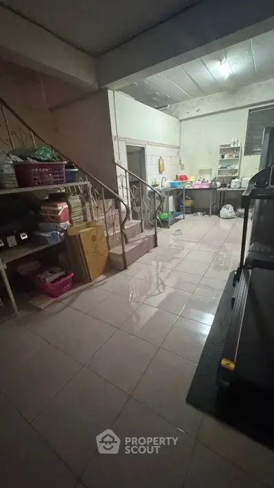 Spacious basement storage area with tiled flooring and metal staircase