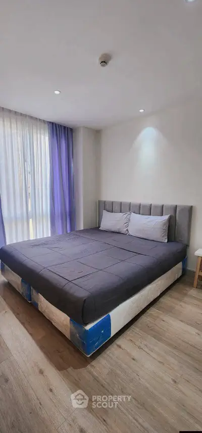 Modern bedroom with stylish bed and natural light, perfect for relaxation and comfort.