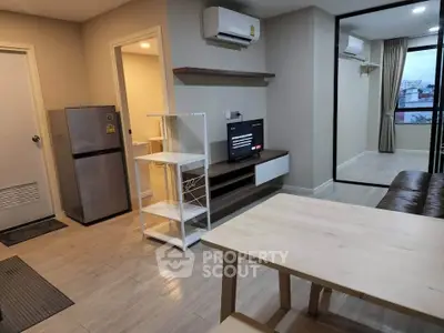 Modern living room with dining area, air conditioning, and sleek furniture in a cozy apartment.