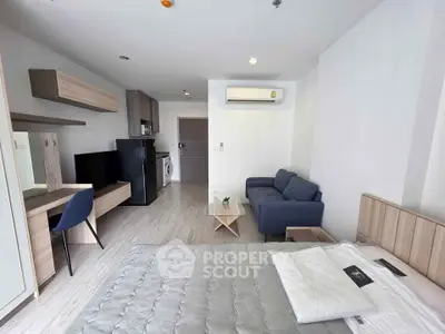 Modern studio apartment with sleek furnishings and open layout, featuring a cozy living area and compact kitchen.