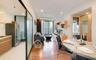 Modern open-plan living room with dining area and kitchen in a stylish apartment.