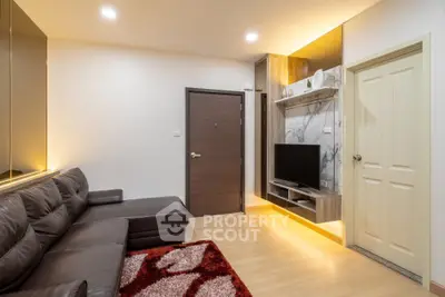 Modern living room with sleek leather sofa and built-in TV unit, featuring warm lighting and stylish decor.