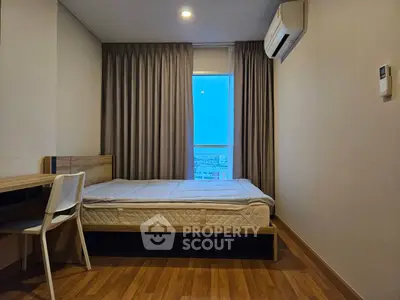 Cozy bedroom with wooden flooring and large window view