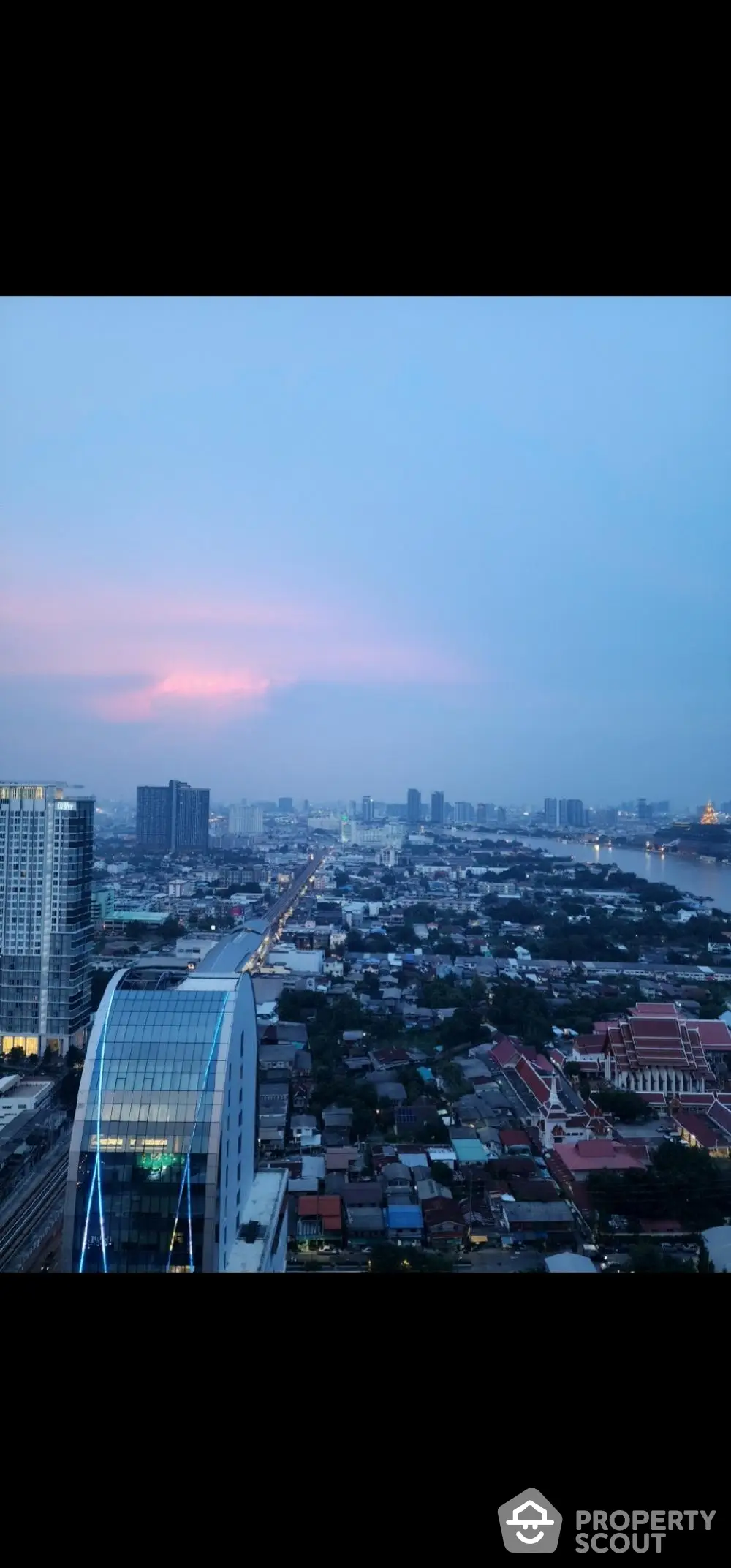 Stunning cityscape view from high-rise building at sunset, showcasing urban skyline and vibrant horizon.