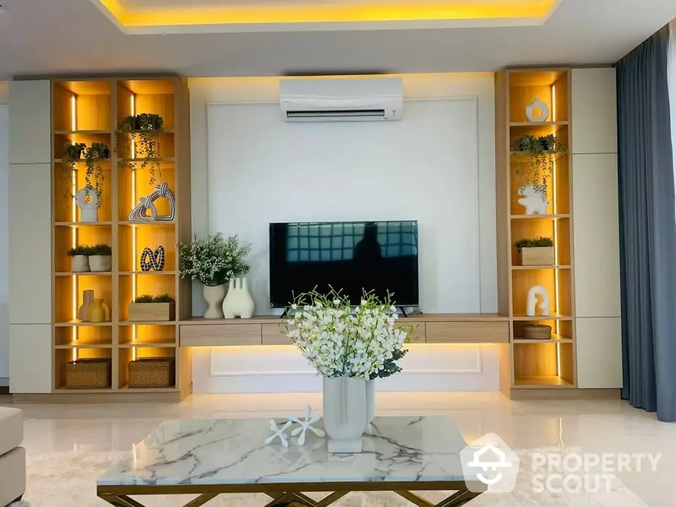 Luxurious living room with elegant marble flooring, modern gold-accent shelving, and ambient lighting creating a warm, inviting atmosphere perfect for relaxation or entertainment.