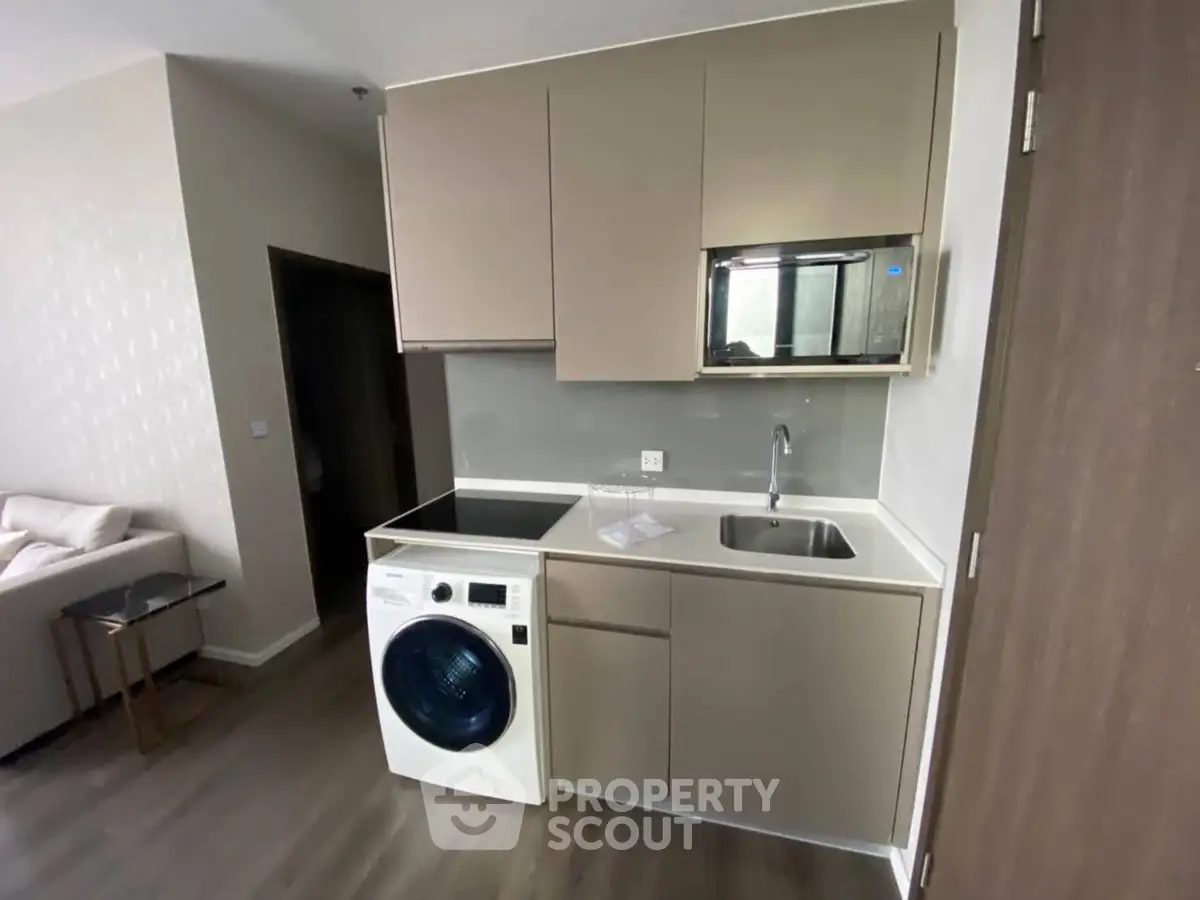 Modern compact kitchen with integrated washing machine and sleek cabinetry