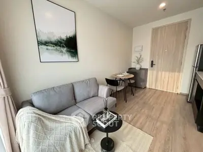 Modern living room with cozy sofa, stylish decor, and dining area in open layout apartment.