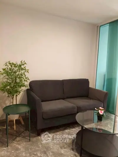 Cozy living room with modern sofa and glass coffee table, perfect for relaxation.