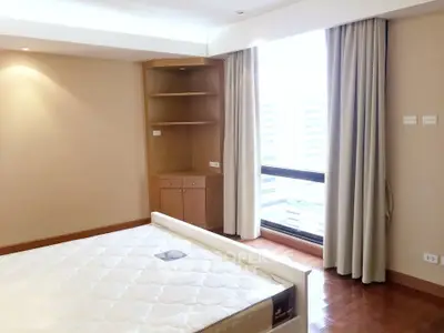 Spacious bedroom with large window and built-in shelves in modern apartment