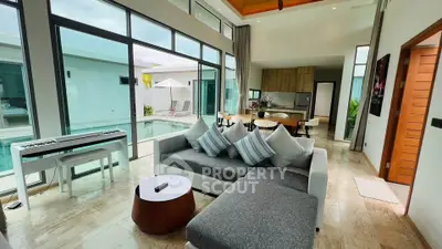 Luxurious open-plan living room with pool view and modern kitchen in a stylish villa.