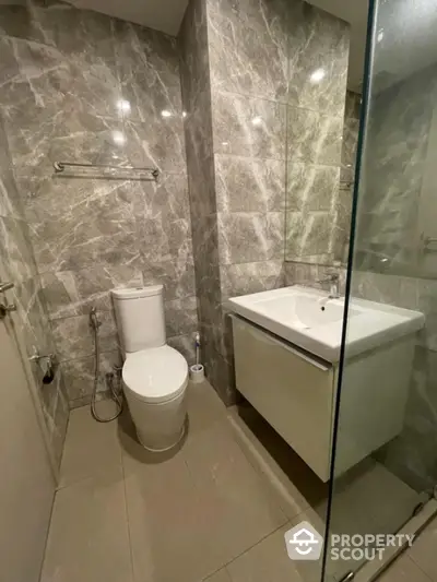 Modern bathroom with marble tiles and sleek fixtures in a contemporary apartment.