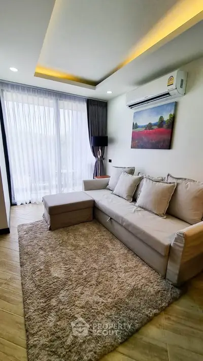 Modern living room with cozy sofa, elegant decor, and large window offering natural light.