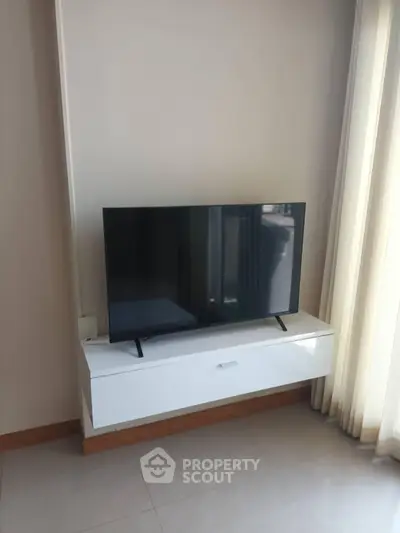 Modern living room with sleek TV setup and natural light
