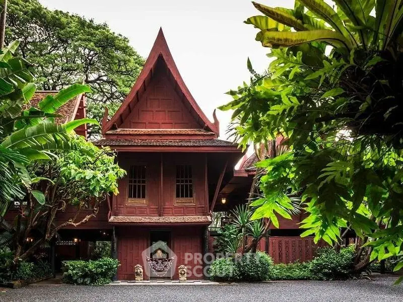 Stunning traditional Thai-style house surrounded by lush greenery, showcasing unique architectural design.