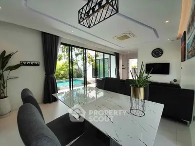 Luxurious open-plan living room with pool view and modern decor
